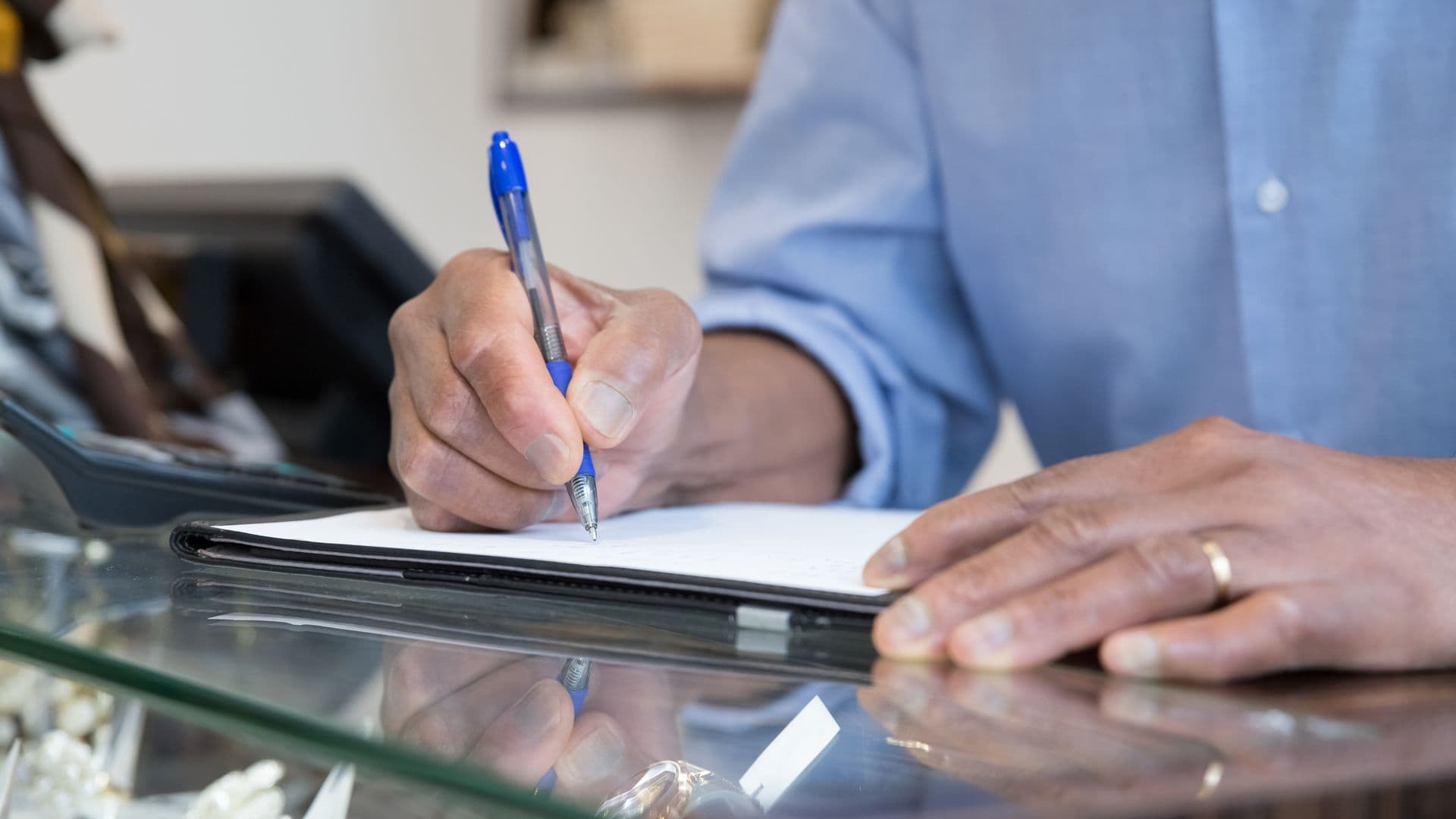 A person writing at a records counter