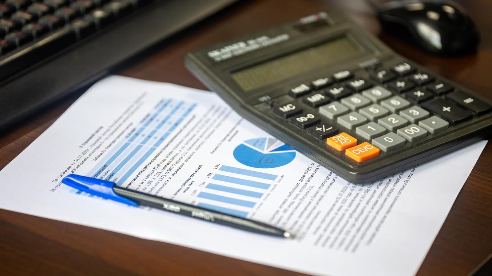 A calculator and a set of keys on a desk beside a property agreement