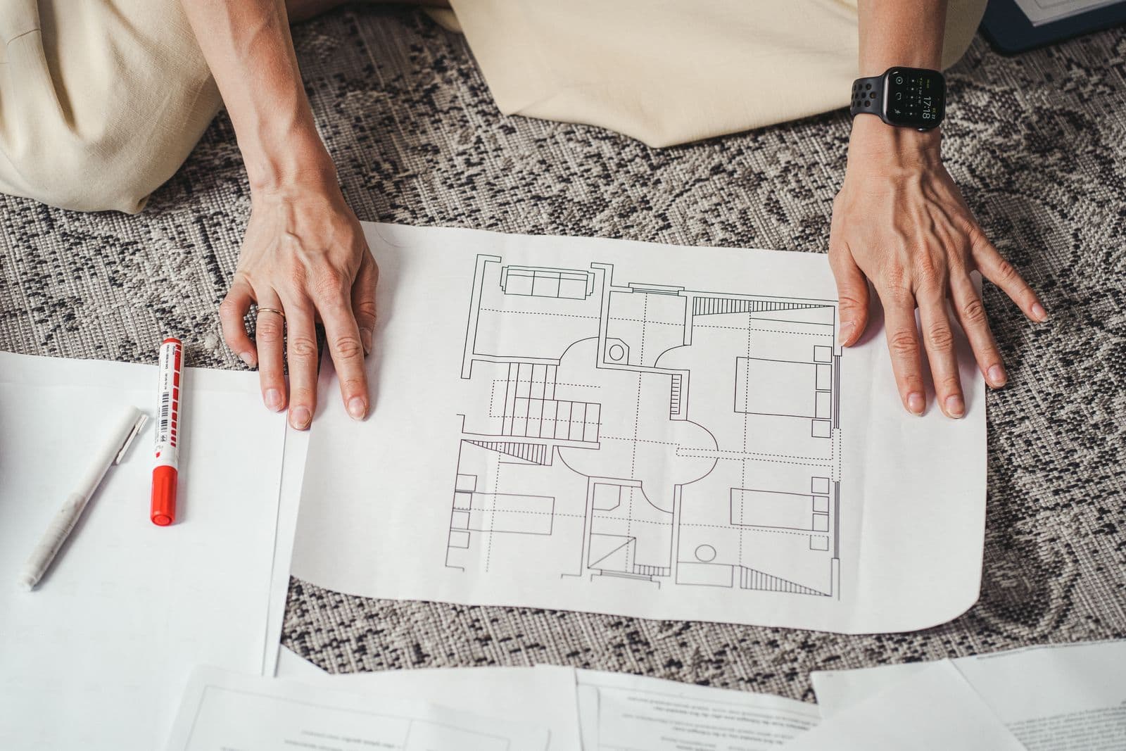 Hands smoothing out a floor plan