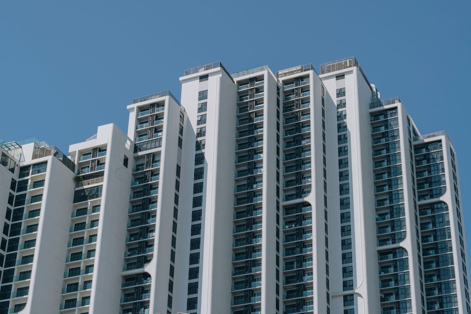 A row of tall white apartment towers with glass balconies