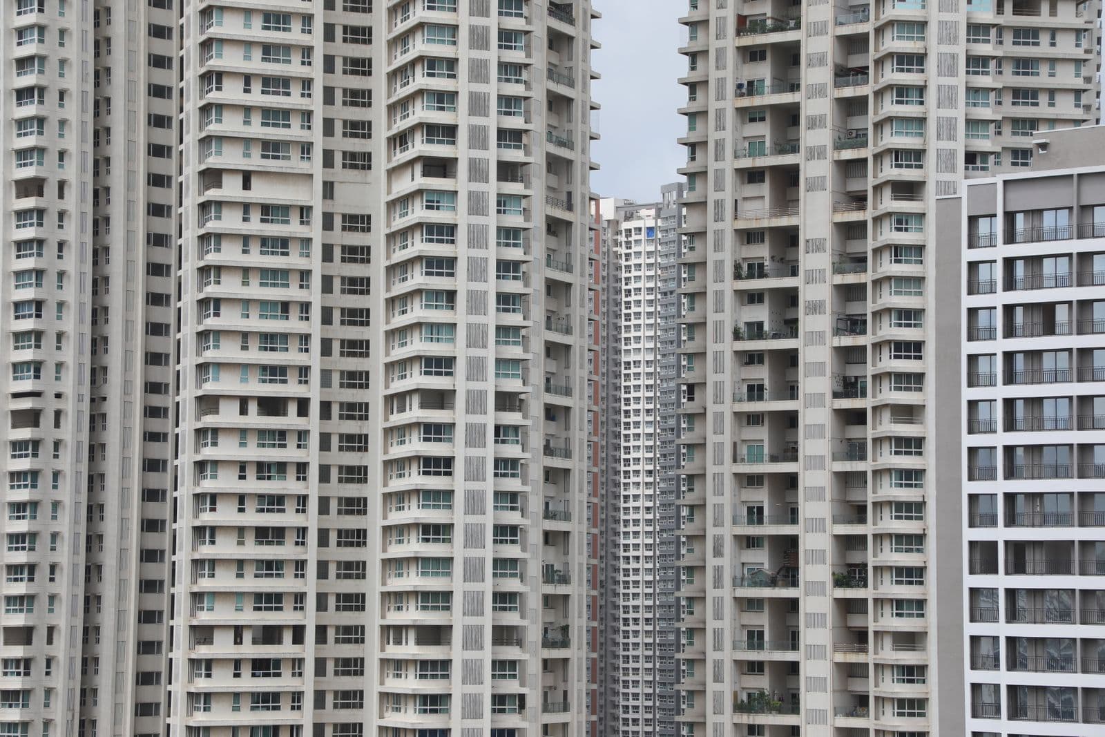 Two tall apartment towers seen close, floor upon floor of balconies