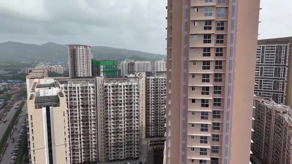 Mumbai residential towers lit up at dusk, seen from above