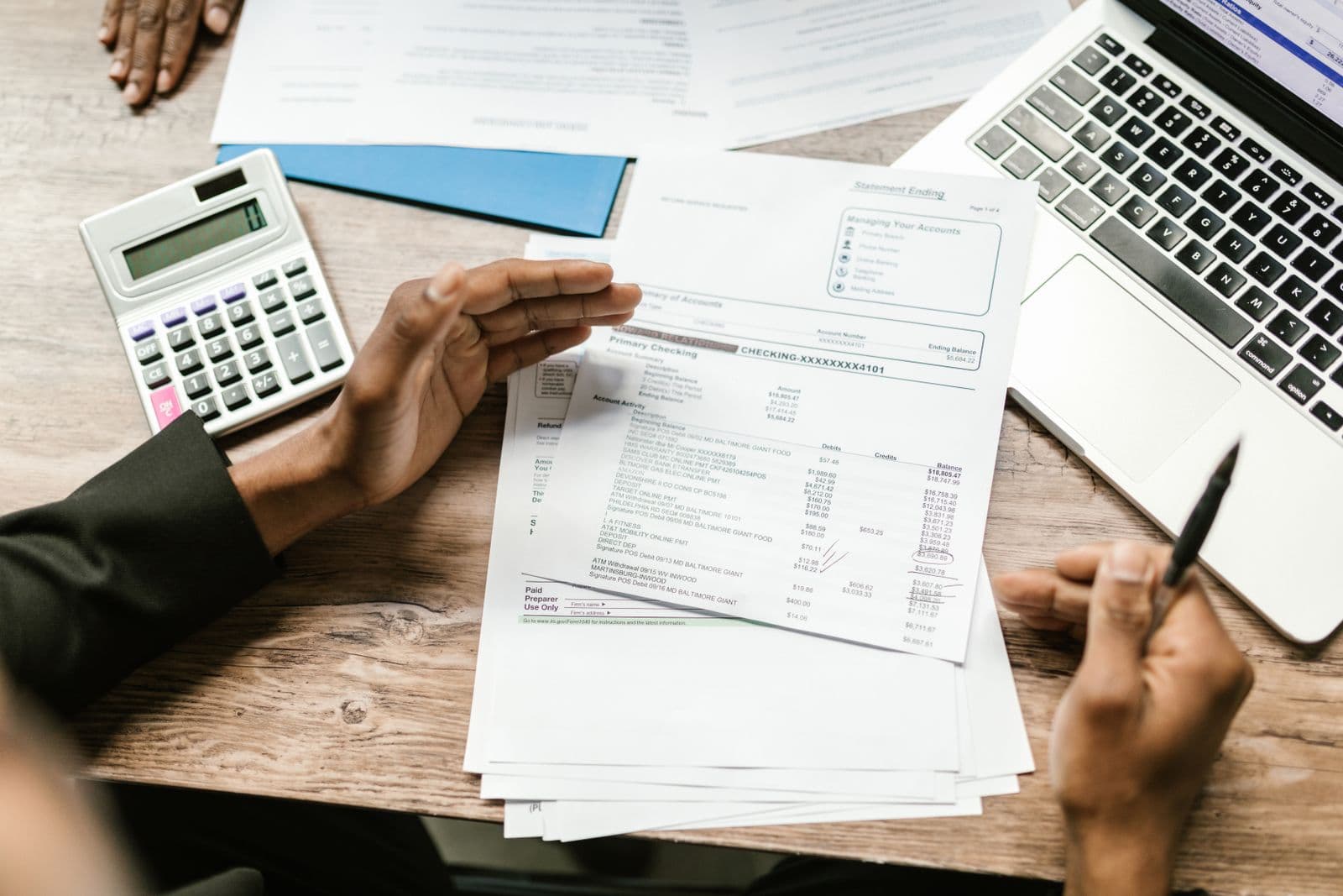 Papers, a calculator and a laptop during a review of figures